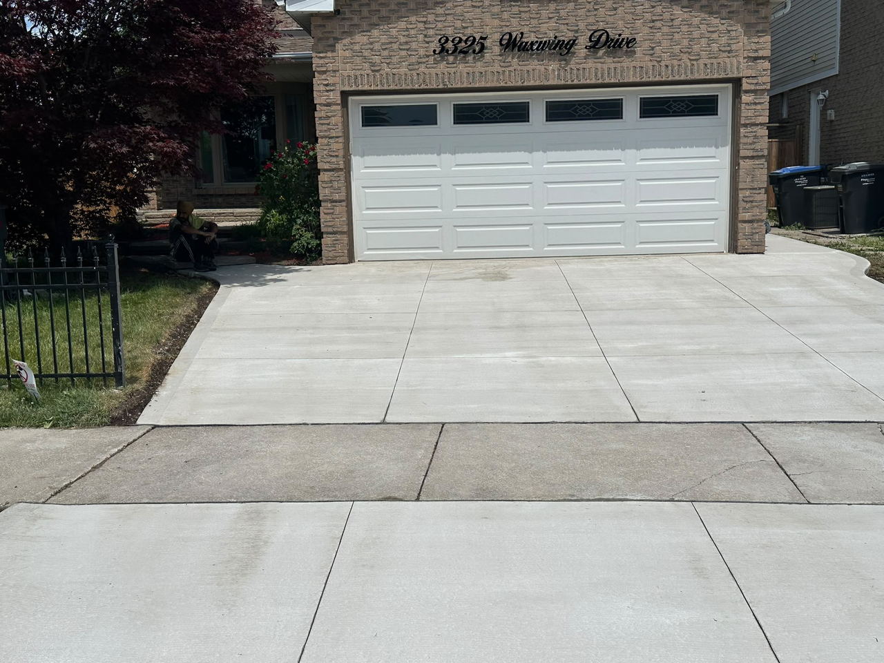 Finished broom-finish concrete driveway leading to a double garage