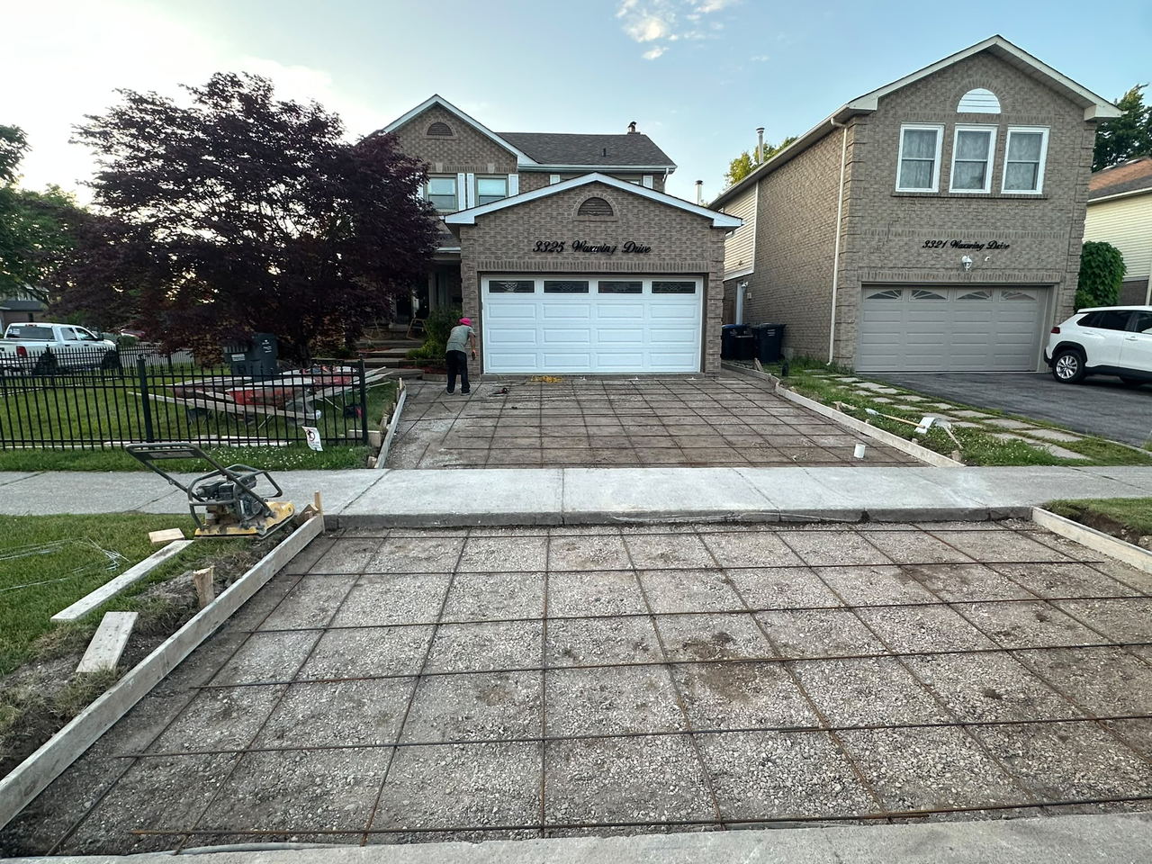 Broom-finish concrete driveway freshly poured and jointed across a double frontage