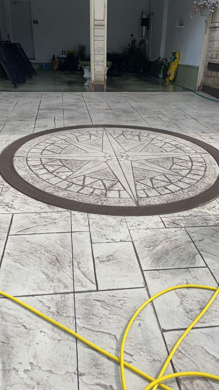 Stamped concrete floor with a decorative compass-rose medallion set into an ashlar pattern
