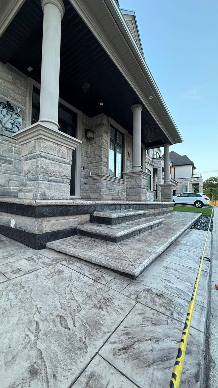 Stamped concrete walkway and steps leading to a columned covered porch